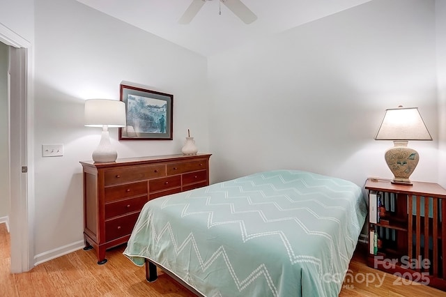 bedroom featuring wood finished floors, a ceiling fan, and baseboards