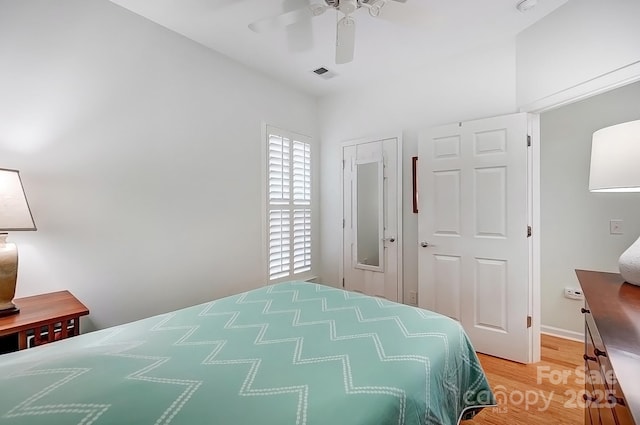 bedroom with a ceiling fan, visible vents, and light wood finished floors