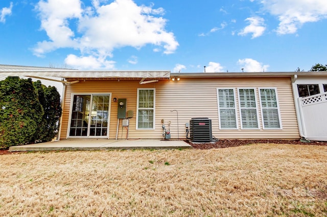 rear view of property with a patio, central AC unit, and a lawn