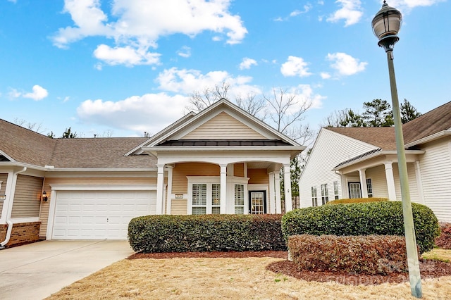 greek revival house featuring a standing seam roof, concrete driveway, an attached garage, and metal roof