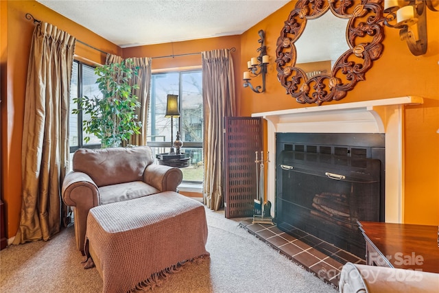 living area featuring light carpet, a fireplace, and a textured ceiling