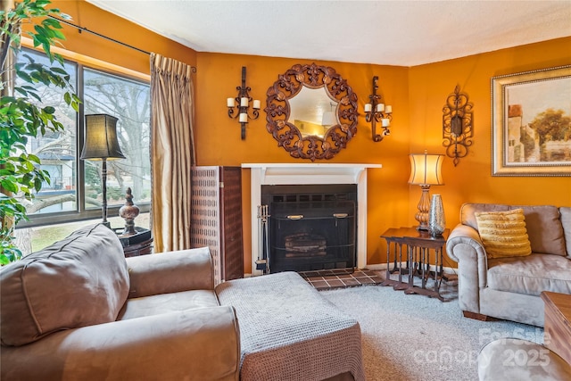 living room featuring baseboards, carpet flooring, and a tiled fireplace