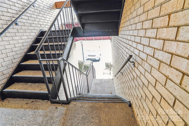 stairs featuring brick wall