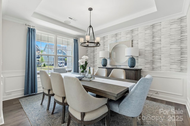 dining space featuring a wainscoted wall, visible vents, a raised ceiling, and an inviting chandelier