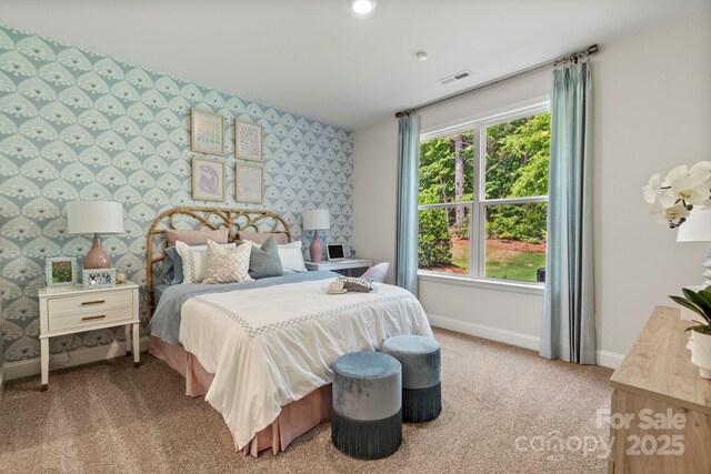 carpeted bedroom with visible vents, wallpapered walls, and baseboards