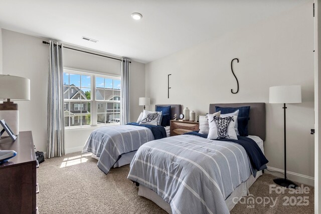 carpeted bedroom featuring baseboards and visible vents