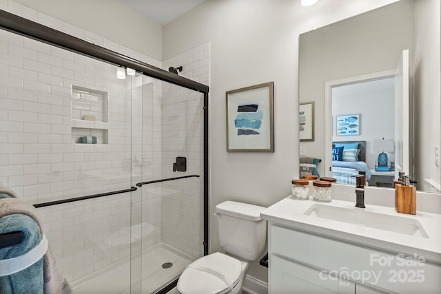 ensuite bathroom featuring toilet, a stall shower, vanity, and ensuite bathroom