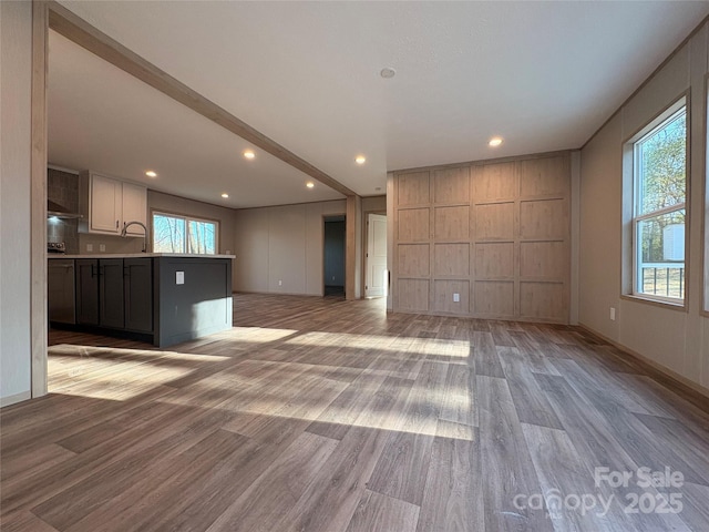 unfurnished living room with recessed lighting, baseboards, and light wood-style flooring