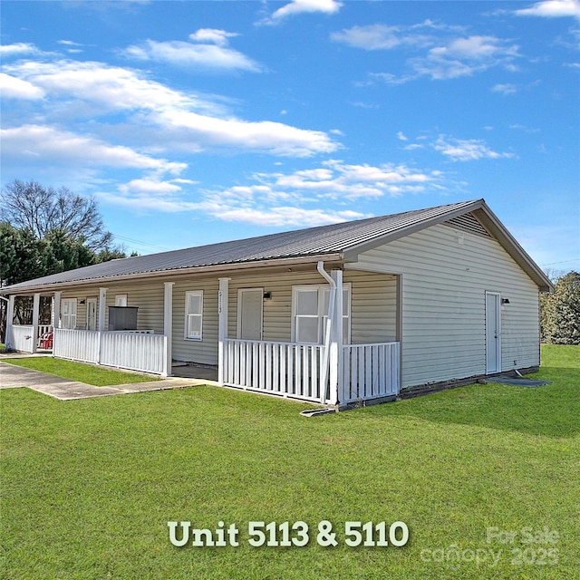 ranch-style house featuring covered porch, metal roof, and a front yard