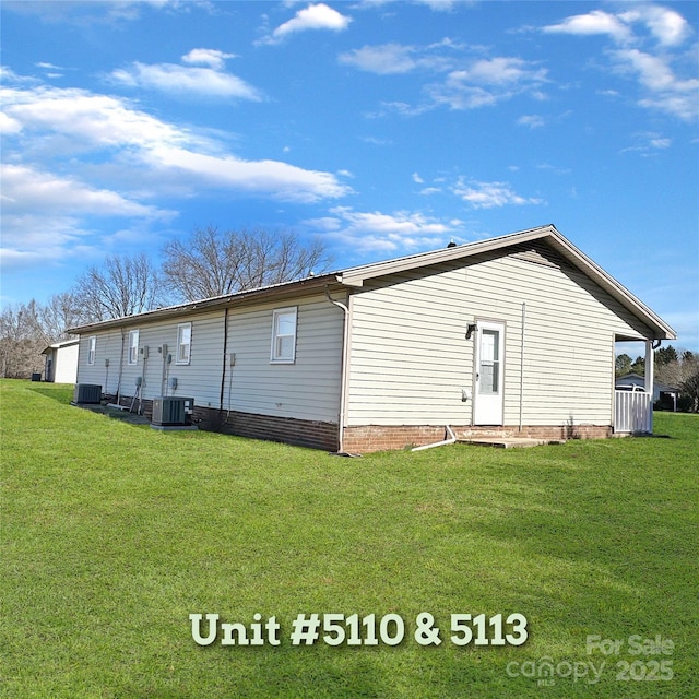 rear view of property with a lawn and cooling unit