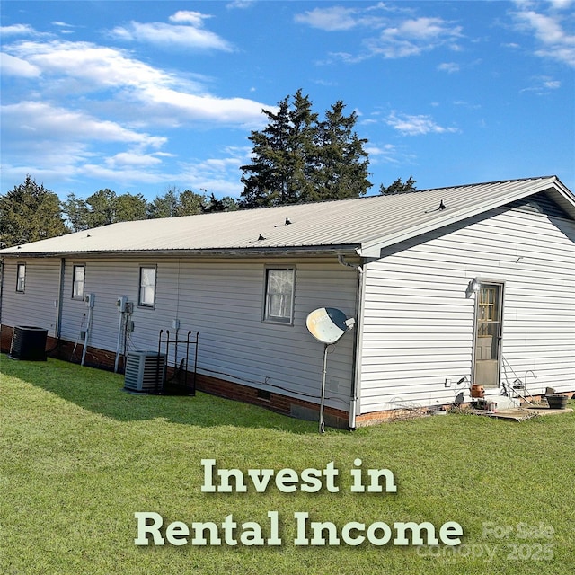 rear view of house with crawl space, cooling unit, metal roof, and a lawn