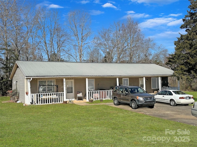 ranch-style house featuring aphalt driveway, a front yard, covered porch, and metal roof