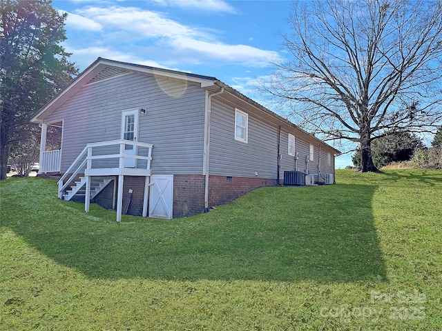 view of home's exterior with stairway, a lawn, and central air condition unit