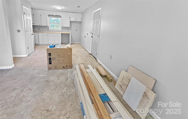 interior space with white cabinetry and baseboards