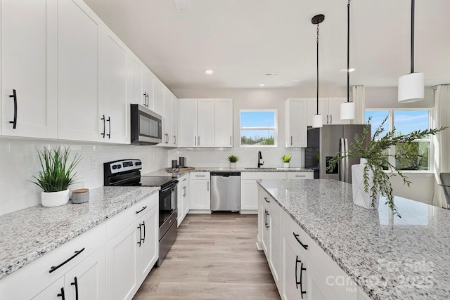 kitchen with light stone counters, stainless steel appliances, white cabinets, hanging light fixtures, and decorative backsplash