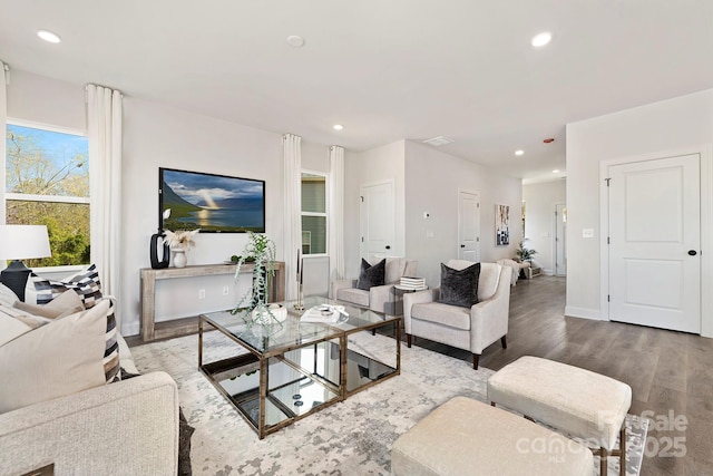 living area with baseboards, wood finished floors, and recessed lighting