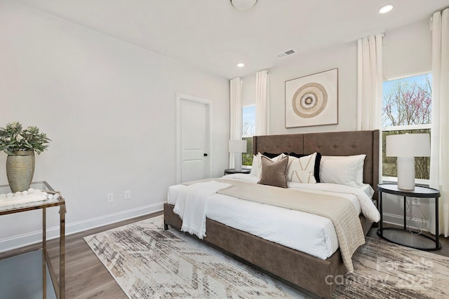 bedroom featuring baseboards, visible vents, wood finished floors, and recessed lighting