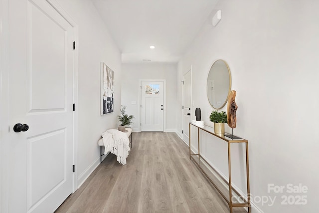 doorway featuring recessed lighting, light wood-style flooring, and baseboards