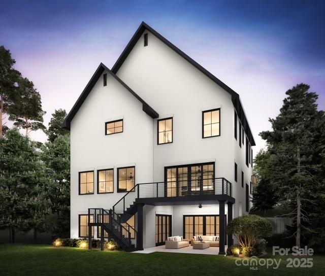 rear view of property with a yard, stucco siding, an outdoor hangout area, a balcony, and stairs