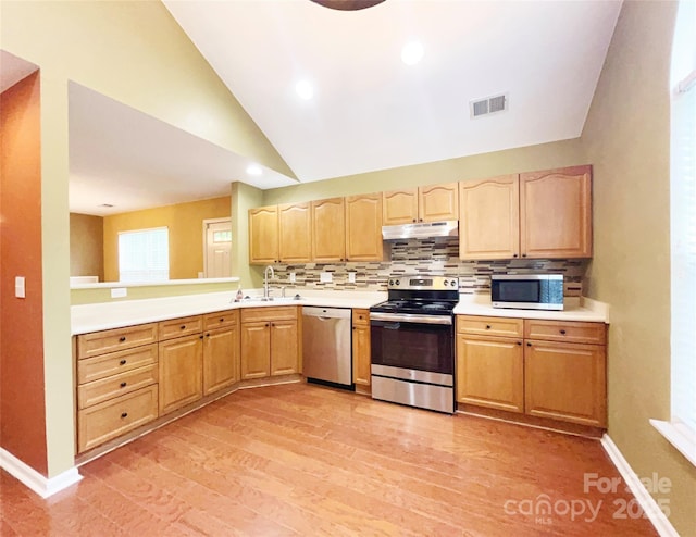 kitchen with under cabinet range hood, visible vents, stainless steel appliances, and light countertops