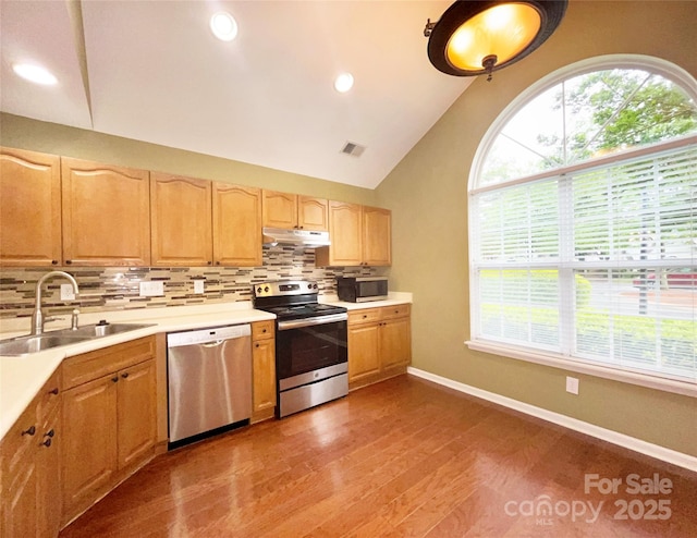 kitchen with stainless steel appliances, visible vents, light countertops, a sink, and under cabinet range hood