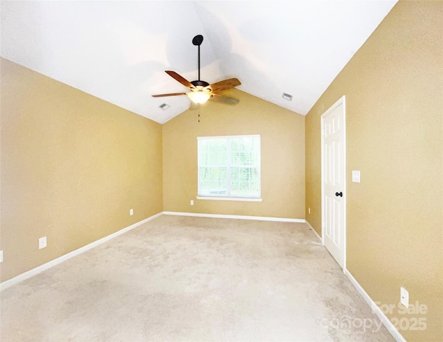 empty room featuring baseboards, visible vents, vaulted ceiling, and a ceiling fan