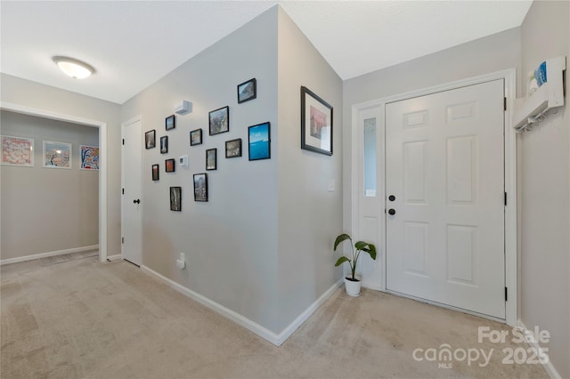 entrance foyer with light colored carpet and baseboards