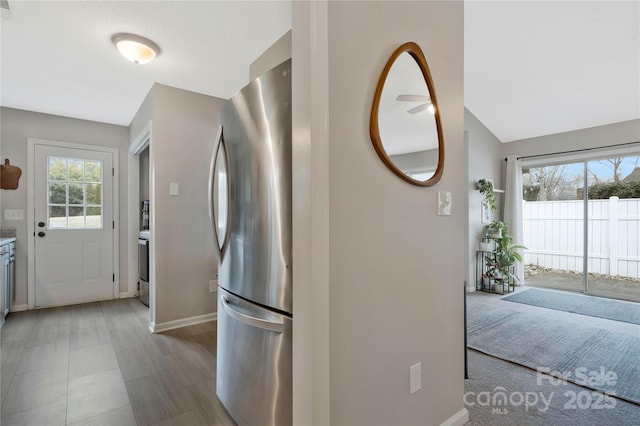 kitchen with freestanding refrigerator, light countertops, and baseboards