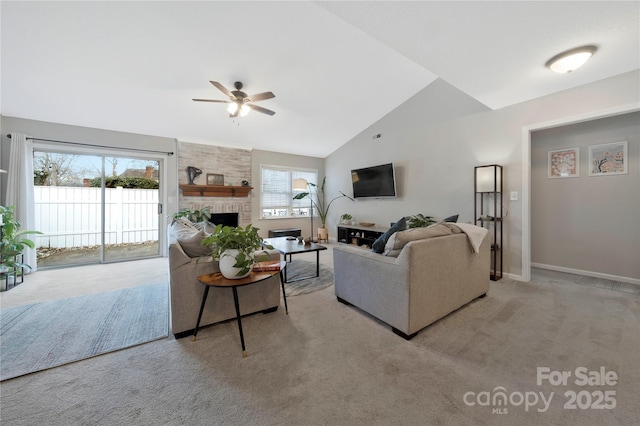 living room featuring baseboards, light colored carpet, ceiling fan, vaulted ceiling, and a fireplace