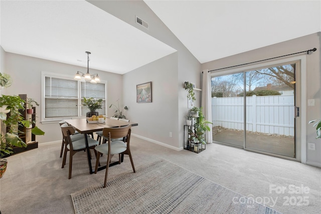 dining space with lofted ceiling, light colored carpet, visible vents, an inviting chandelier, and baseboards