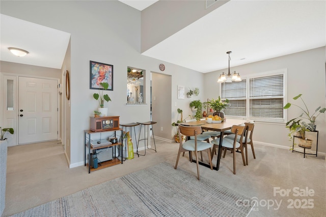 dining space with a notable chandelier, baseboards, and light colored carpet