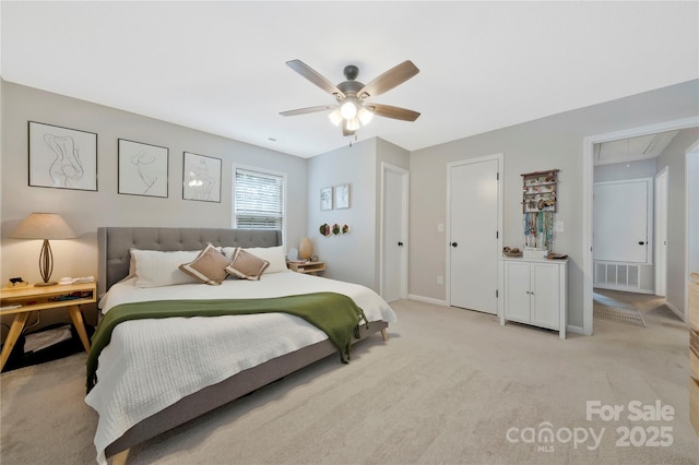 bedroom with light carpet, attic access, baseboards, visible vents, and a ceiling fan