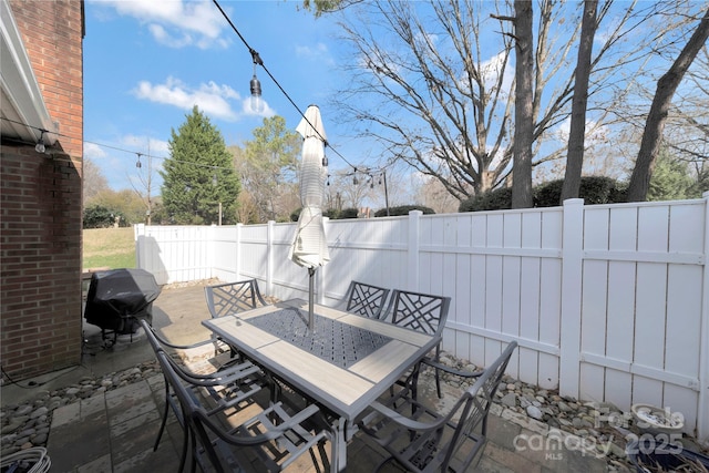 view of patio / terrace with a grill, outdoor dining area, and a fenced backyard