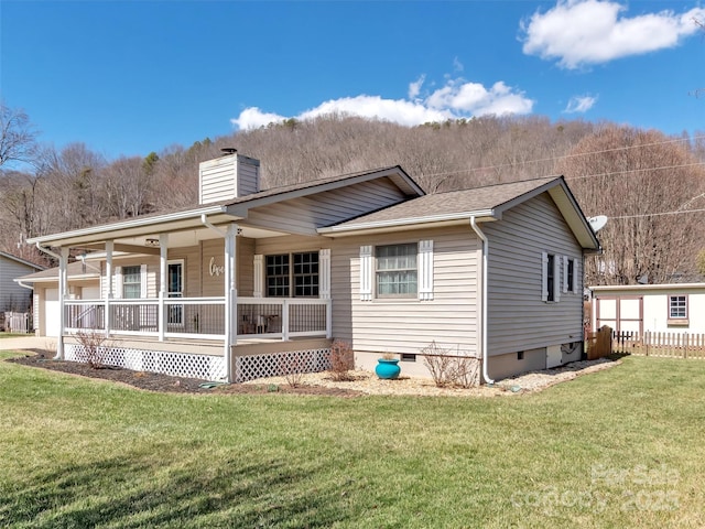 rear view of property with a shingled roof, a chimney, crawl space, a yard, and a porch