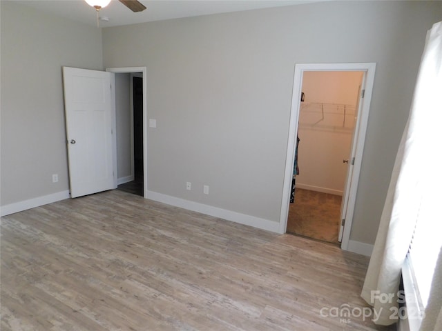2504 Hovis Rd, Lincolnton, NC 28092 - unfurnished bedroom featuring wood finished floors, a walk in closet, a closet, and baseboards
