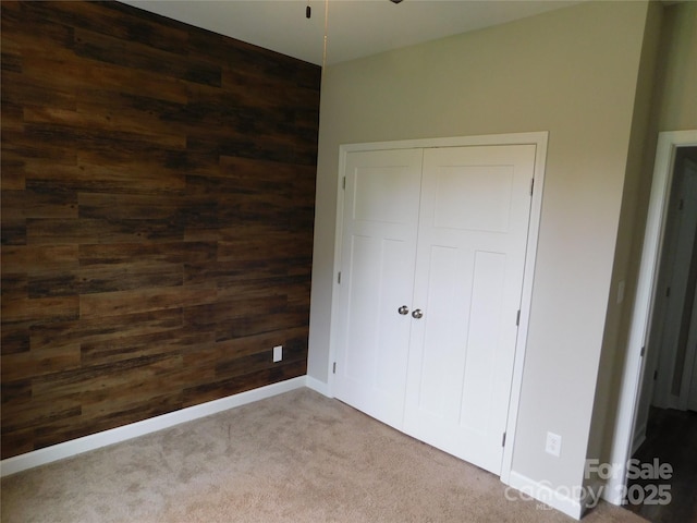 2504 Hovis Rd, Lincolnton, NC 28092 - unfurnished bedroom with wooden walls, carpet flooring, a closet, and baseboards