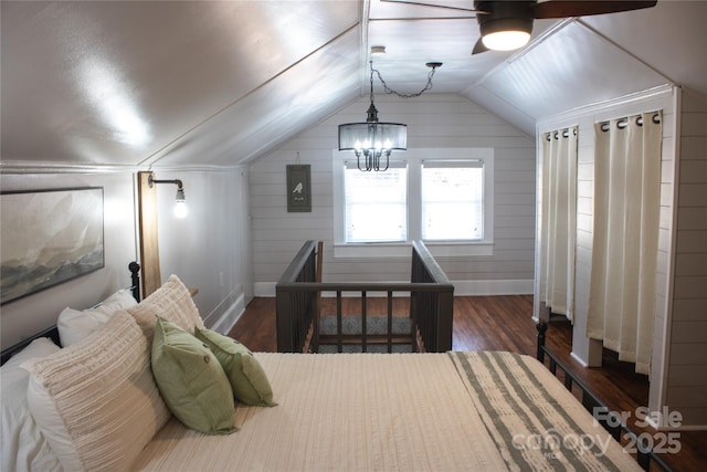 bedroom featuring lofted ceiling, baseboards, a chandelier, and wood finished floors