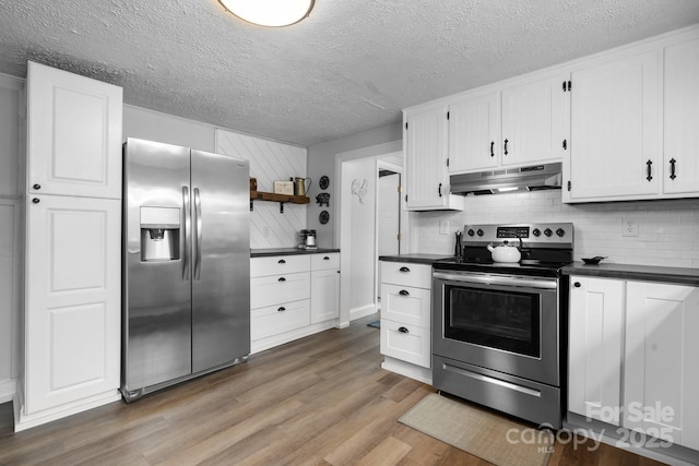 kitchen with dark countertops, under cabinet range hood, open shelves, and stainless steel appliances