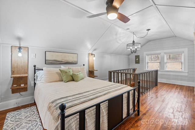 bedroom with lofted ceiling, a chandelier, hardwood / wood-style flooring, and baseboards