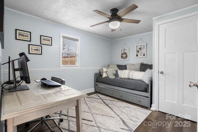 office space featuring ceiling fan, a textured ceiling, wood finished floors, baseboards, and ornamental molding