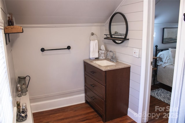 bathroom featuring vanity, connected bathroom, and wood finished floors