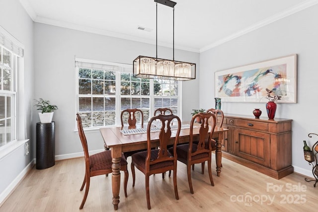 dining space featuring ornamental molding, baseboards, visible vents, and light wood finished floors