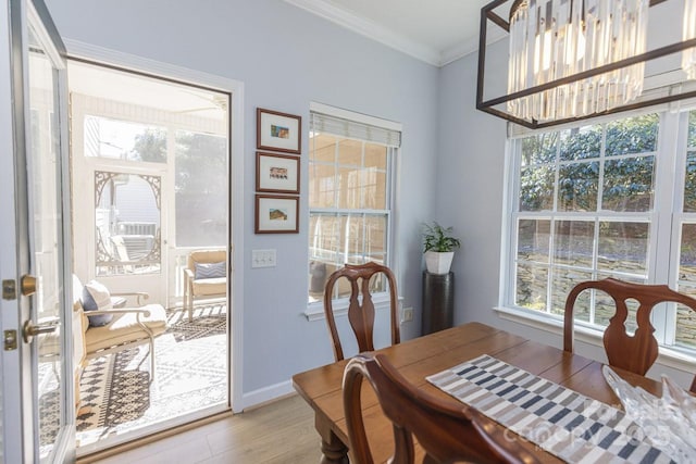 dining area with ornamental molding, baseboards, and light wood finished floors