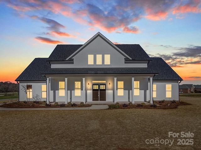 view of front of home featuring a shingled roof and a front lawn