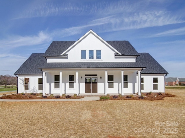 modern inspired farmhouse featuring a porch and roof with shingles