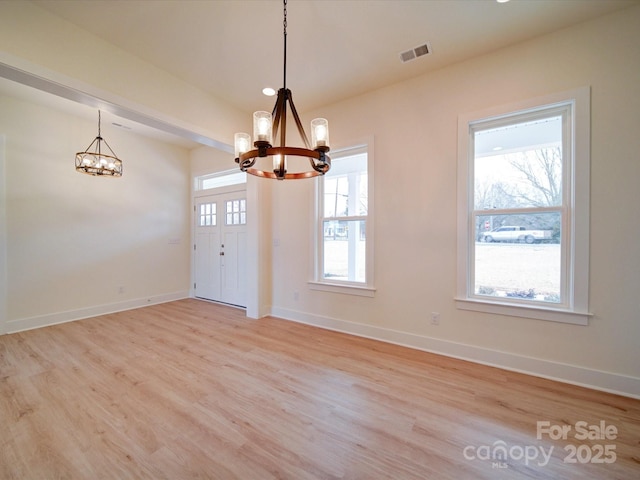 interior space featuring a chandelier, a healthy amount of sunlight, and visible vents