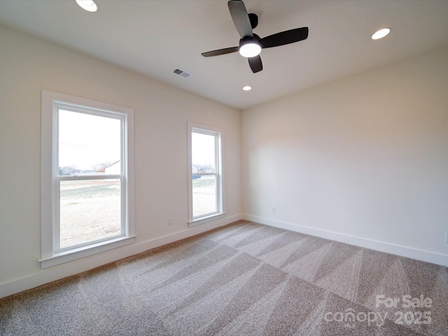 spare room featuring baseboards, recessed lighting, visible vents, and light colored carpet