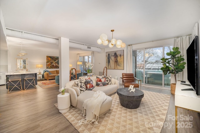 living area featuring light wood-type flooring and an inviting chandelier