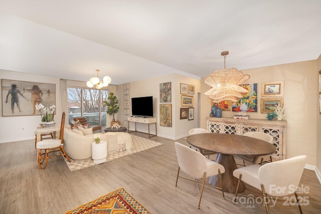 dining area featuring an inviting chandelier, baseboards, and wood finished floors