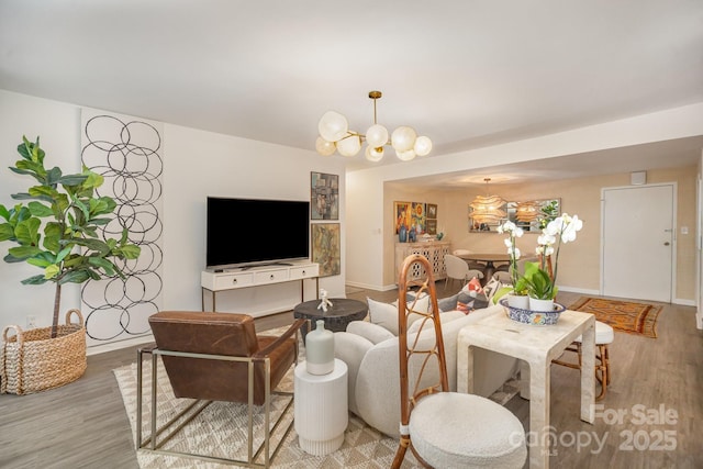 living area with baseboards, light wood-style flooring, and an inviting chandelier